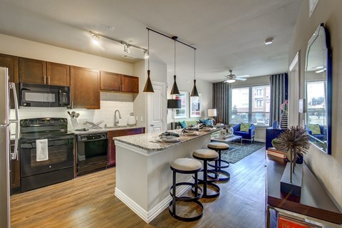 A modern kitchen with a large island and stools.