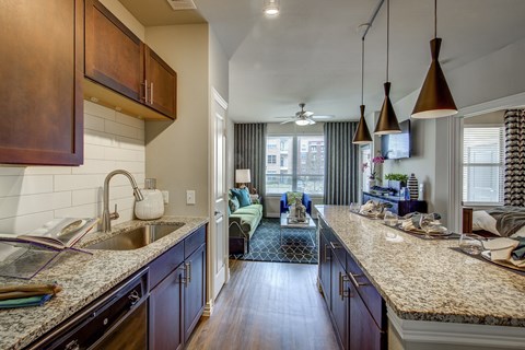 A kitchen with dark wood cabinets and granite countertops.