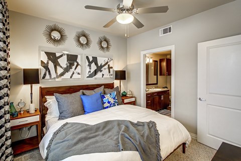A bedroom with a large bed and a ceiling fan.
