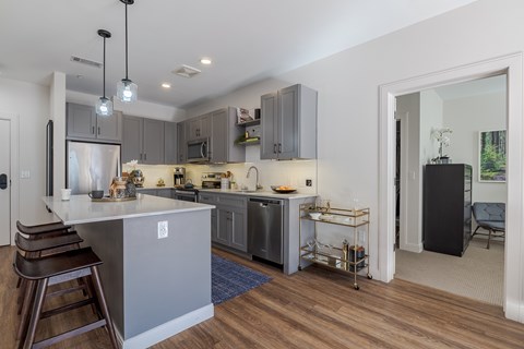 A modern kitchen with a bar area and a dining table.
