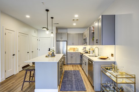 A modern kitchen with a white island and stainless steel appliances.