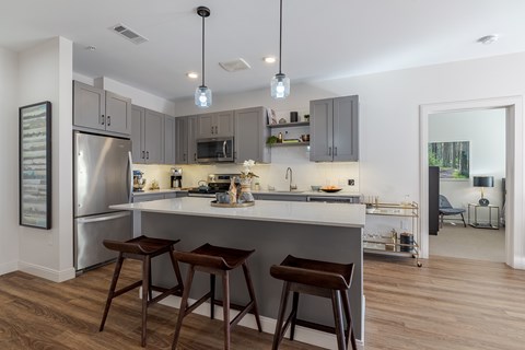 A kitchen with a refrigerator, microwave, and oven.