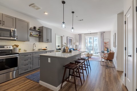 A modern kitchen with a large island and wooden floors.