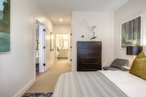A bedroom with a large bed and a painting on the wall.