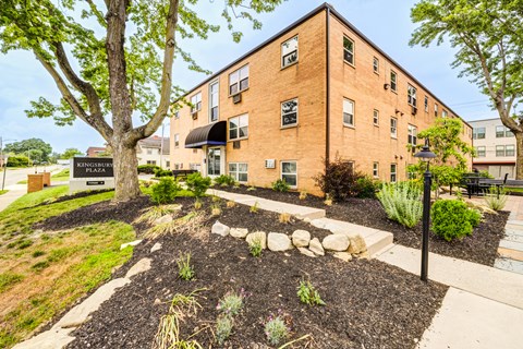 A brick building with a garden in front.