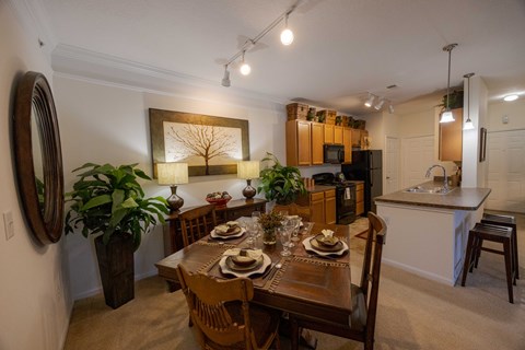 A dining room with a wooden table set for a meal.