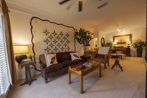 A living room with a brown couch and a wooden coffee table.