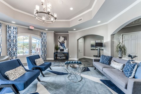 A living room with blue chairs and a grey couch.