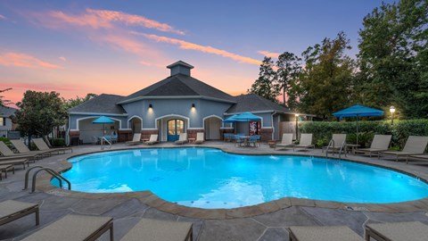 A swimming pool surrounded by lounge chairs and umbrellas.