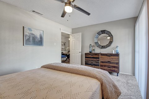 A bedroom with a large bed and a mirror on the wall.