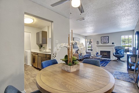 A living room with a wooden table and blue chairs.