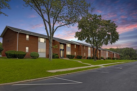 A long row of houses with a tree in front of the first house.