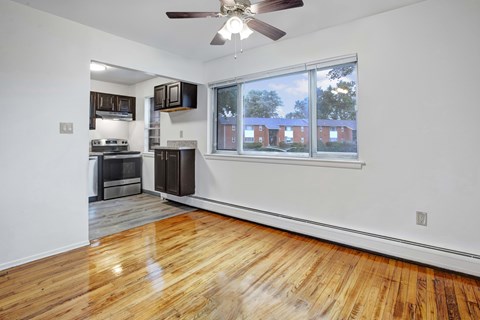 A room with a wood floor and a window overlooking a building.