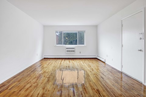 A room with wooden flooring and a window.