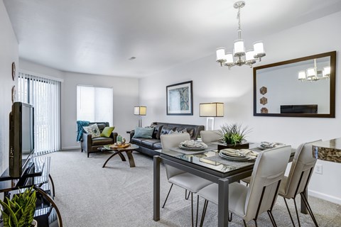 A modern dining room with a glass table and chairs.