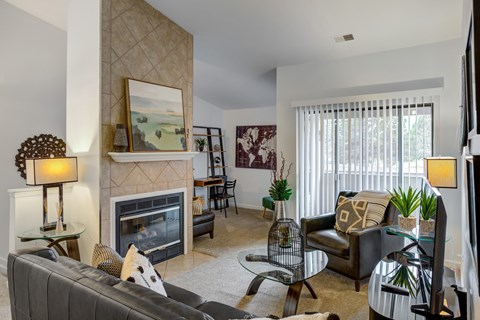 A living room with a fireplace and a painting above it.