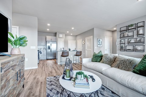 A modern living room with a white couch and a coffee table in the center.