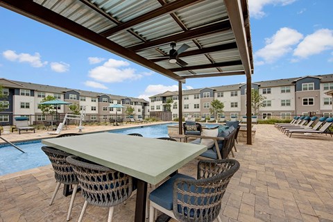A patio with a table and chairs is surrounded by apartment buildings.