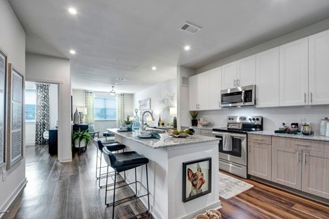 A modern kitchen with a white island and stainless steel appliances.