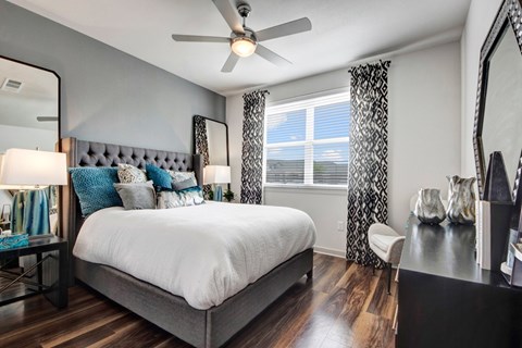 A bedroom with a large bed and a ceiling fan.