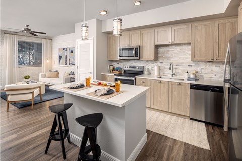 A kitchen with a white island and wooden cabinets.