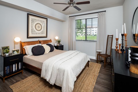 A bedroom with a large bed and a ceiling fan.