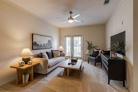 A living room with a couch, a chair, a coffee table, and a painting on the wall.