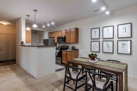A kitchen with a table and chairs in front of it.