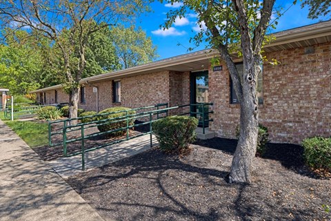 A brick building with a tree in front.