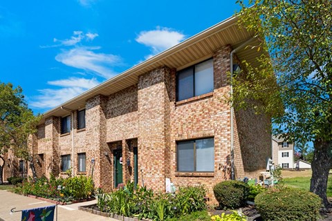 A brick building with a green door and windows.