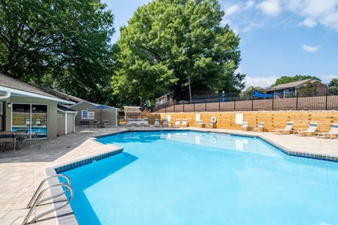 A large swimming pool surrounded by trees and a fence.
