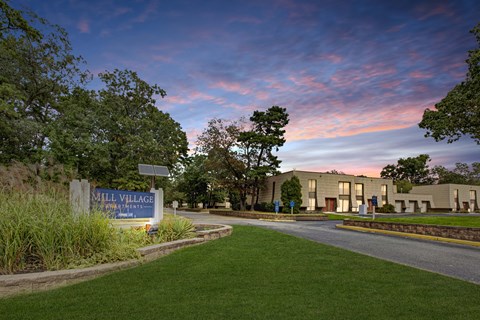 A sign that says Mill Village stands in front of a building.