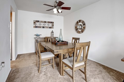 A dining room with a wooden table and chairs.