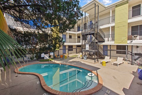 A small pool in a courtyard surrounded by apartment buildings.