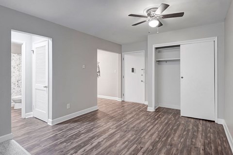A room with a ceiling fan and wooden flooring.