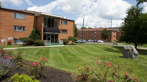 A large brick building with a green lawn in front.