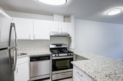 A kitchen with a refrigerator, oven, and stove.