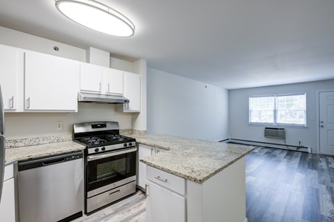 A kitchen with white cabinets and a granite countertop.