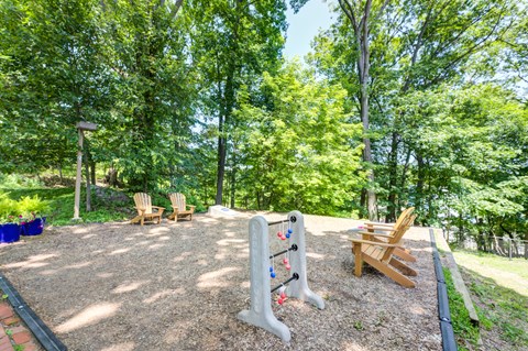 A playground with a slide and two chairs.