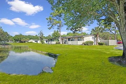 A house with a pond in front of it.