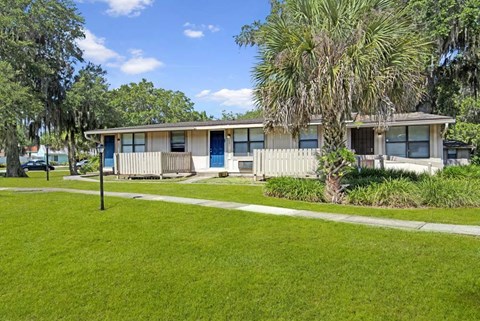 A house with a blue door and a white fence.