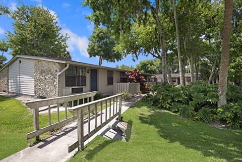 A house with a deck and trees in the background.