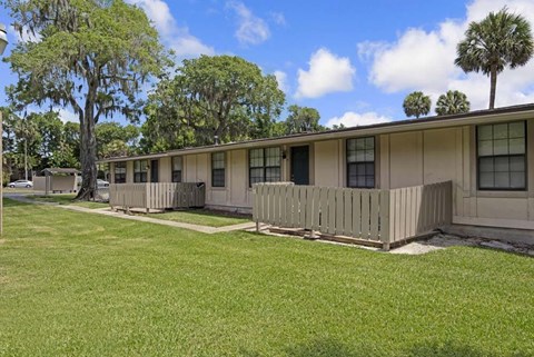 A row of houses with a green lawn in front.