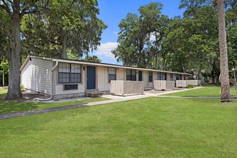 A row of houses with green lawns in front.