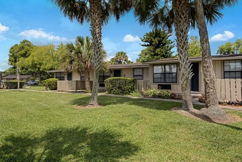 A row of houses with trees in front.