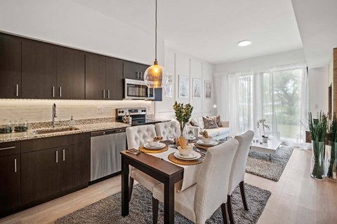 A modern kitchen with a dining table set for two.
