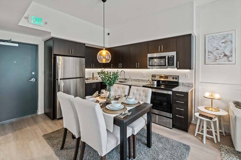 A modern kitchen with a dining table set for four.