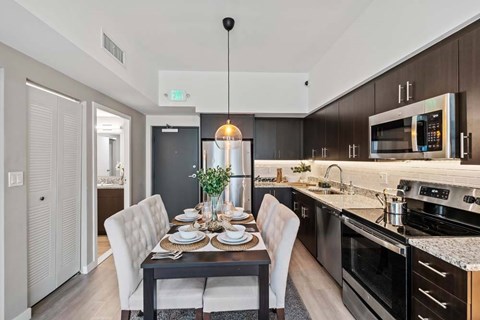 A modern kitchen with a dining table set for two.