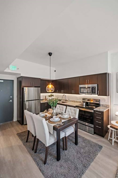 A modern kitchen with a dining table set for four.