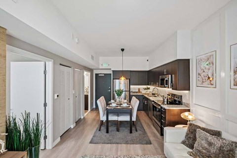 A modern kitchen with a dining table set for two.